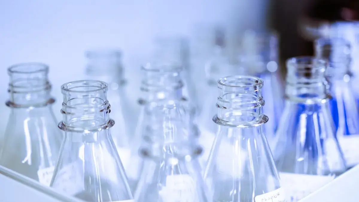 Empty narrow-neck conical flasks standing on a packing tray