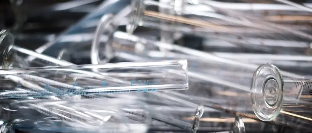 A heap of empty glass tubes lying loose, catching the light